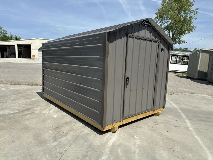 8x12 gray metal shed with horizontal metal siding and a single end door, on a paved lot