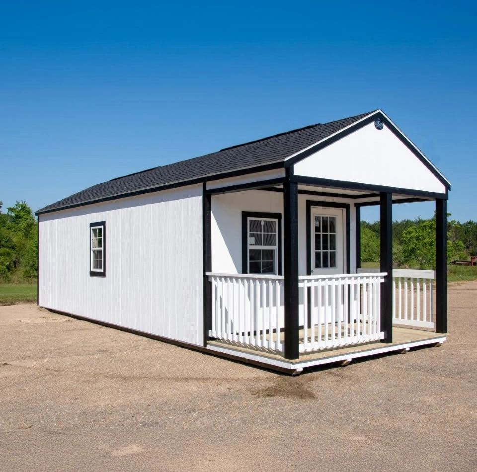 White cabin with covered front porch and railing