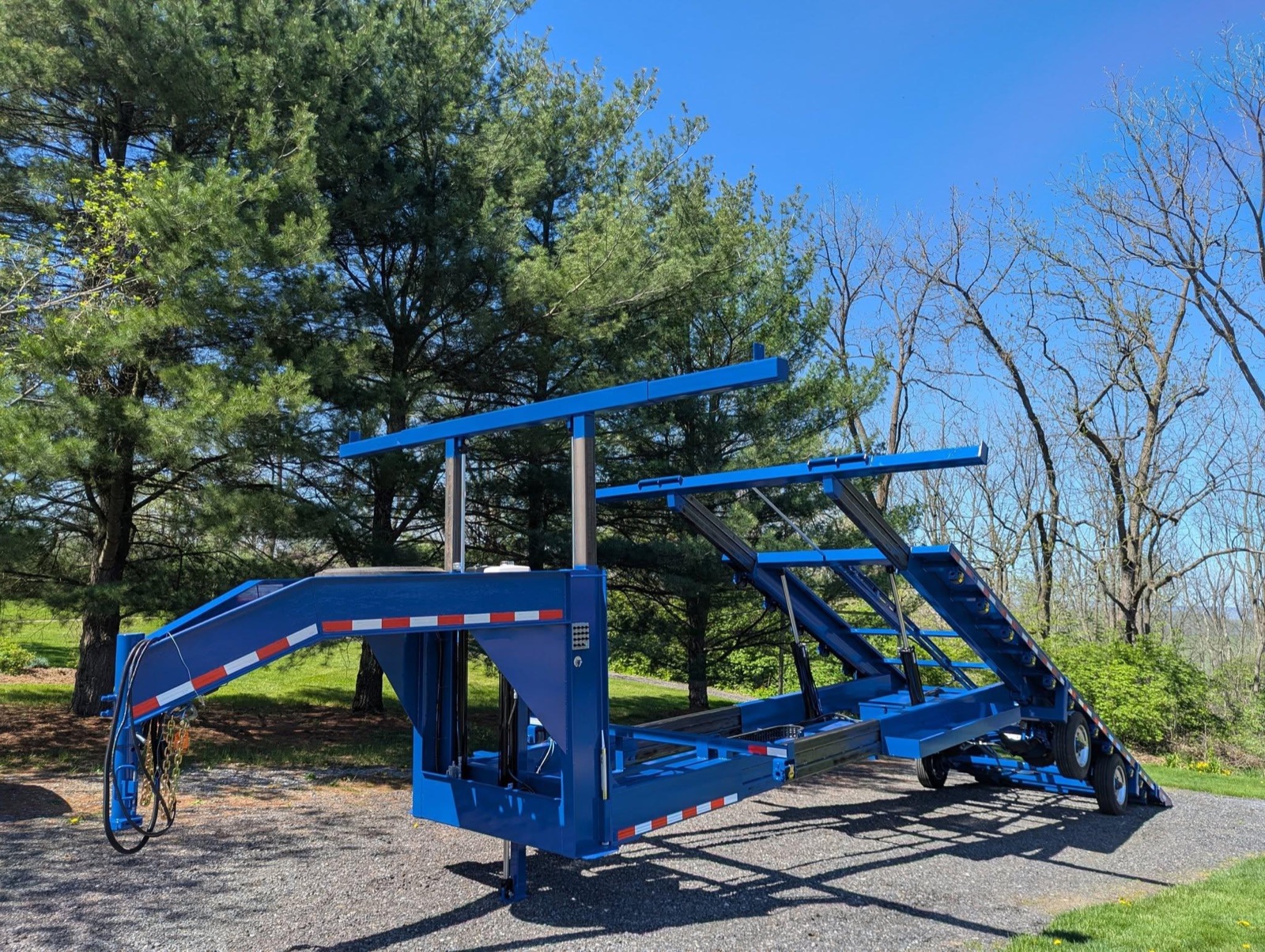 Blue Creekside gooseneck shed trailer parked on gravel